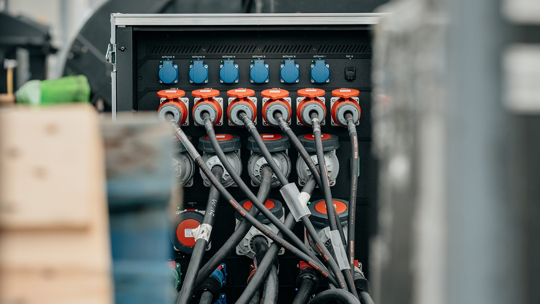 Rear of a PDU with orange-ring Socapex cable connections and blue CEE sockets.