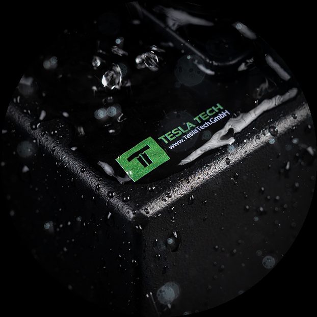 Tesla Tech logo on a black PDU housing covered with water droplets.